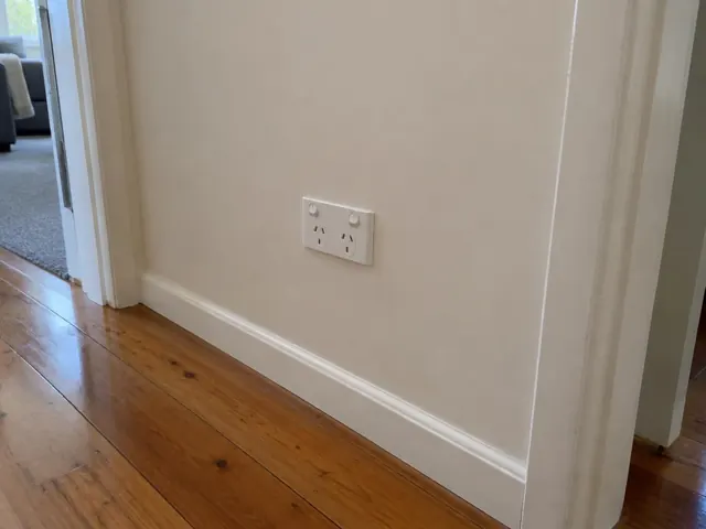 Double power point on a cream hallway wall above timber floorboards in Lakelands