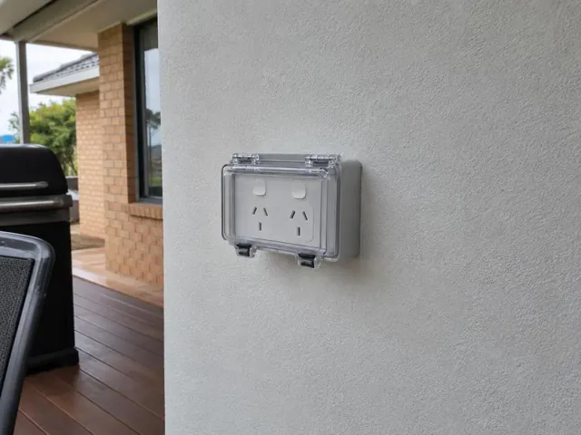 Outdoor double power point on a rendered exterior wall under a covered patio in Eleebana